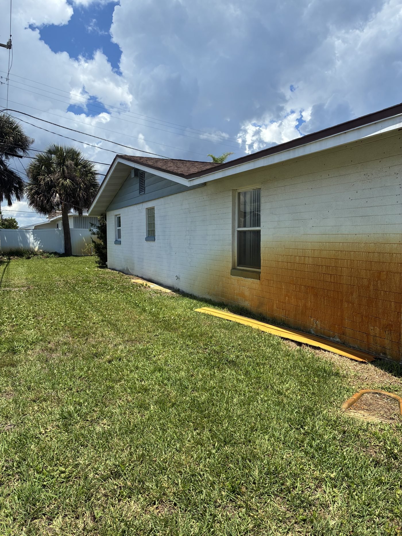 Home exterior before, stained and flagged