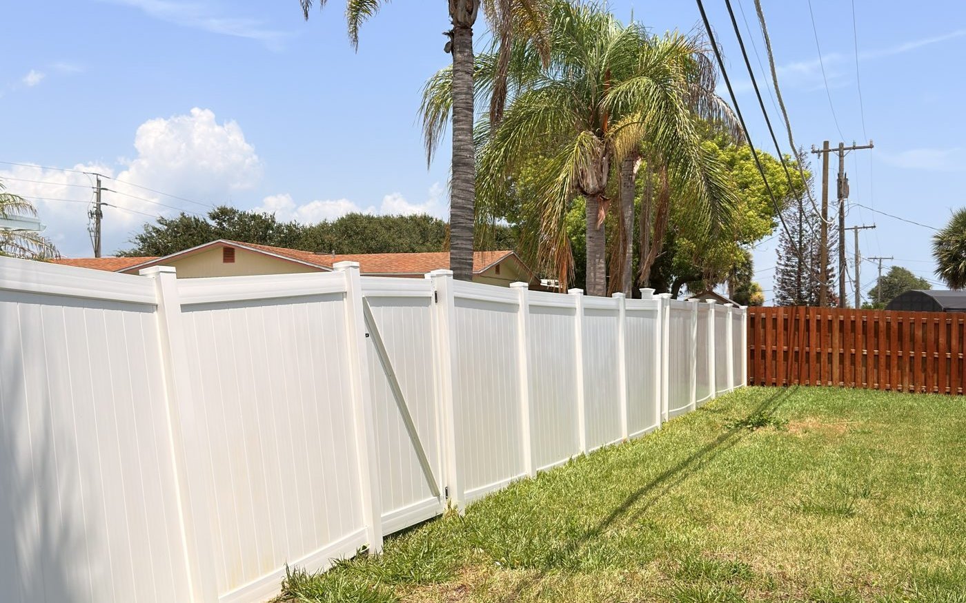A clean white vinyl fence in Volusia County after soft washing