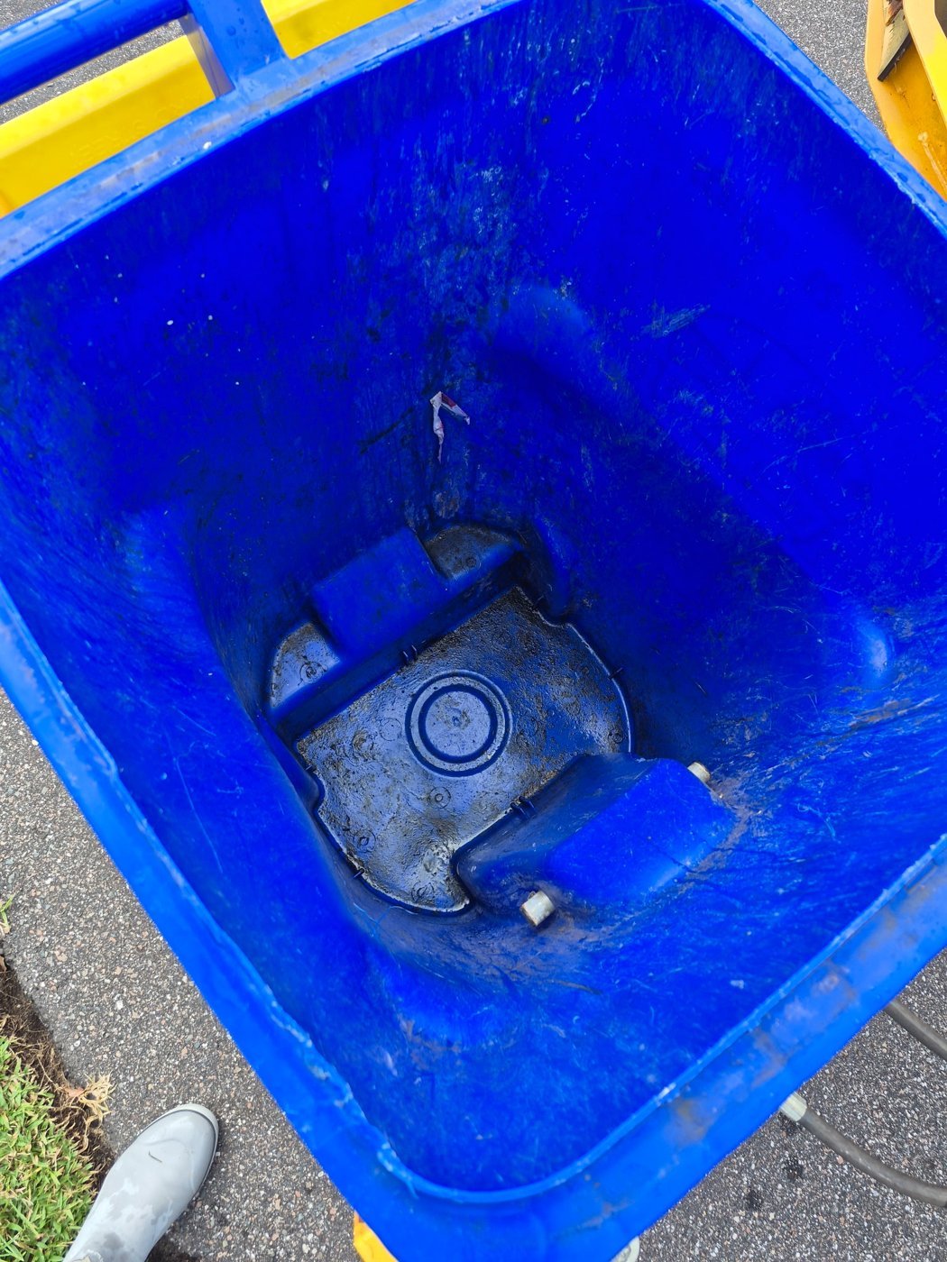 Inside of a trash bin before, dirty and caked